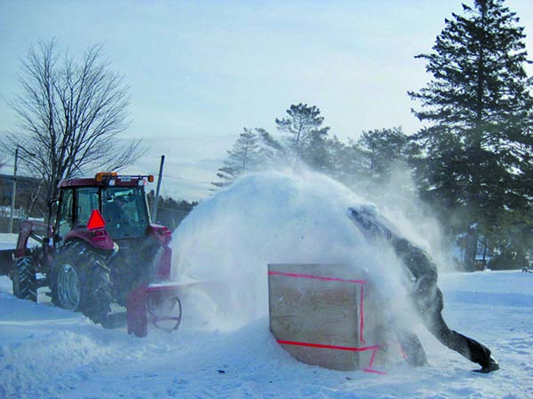 Fabrication d’un bloc. Michel Côté sous la neige, Dominique Daigle au tracteur. Photo par Dominique Langevin 